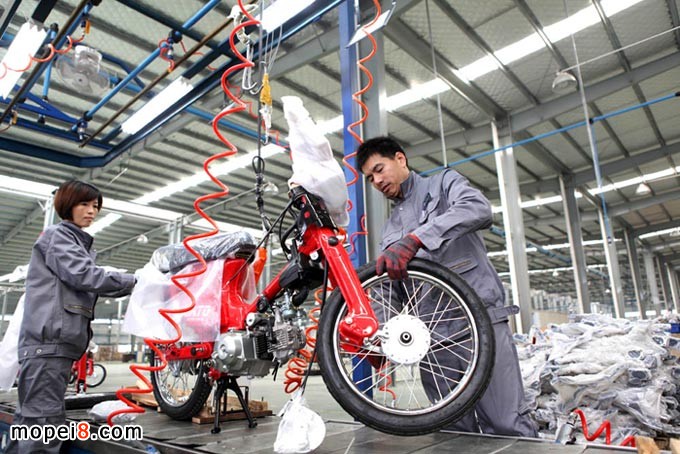 重慶安第斯摩托車技術(shù)工人在自動成車流水生產(chǎn)線組裝摩托車